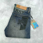 Burberry blue denim jeans with front flap pocket and tan logo patch