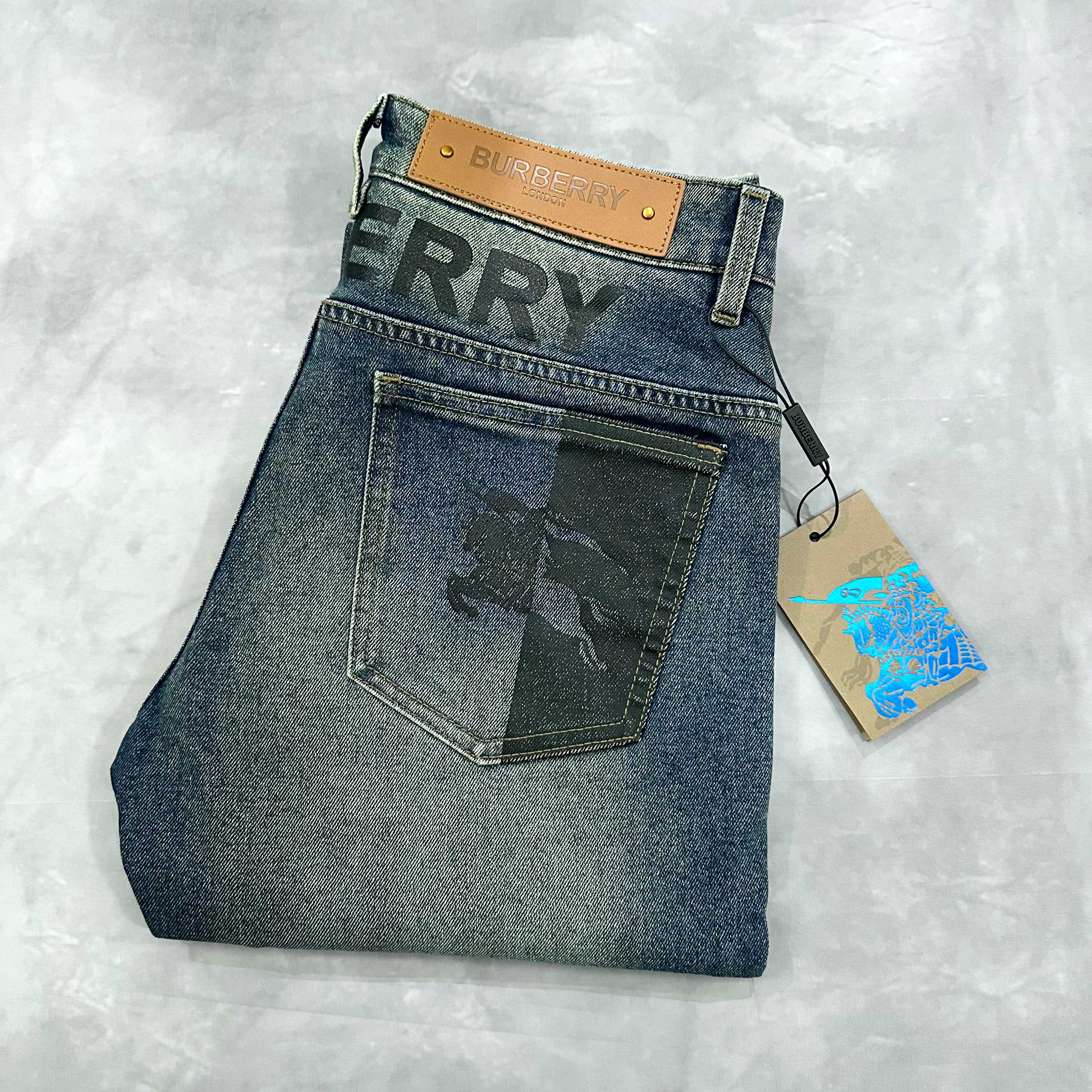 Burberry blue denim jeans with front flap pocket and tan logo patch