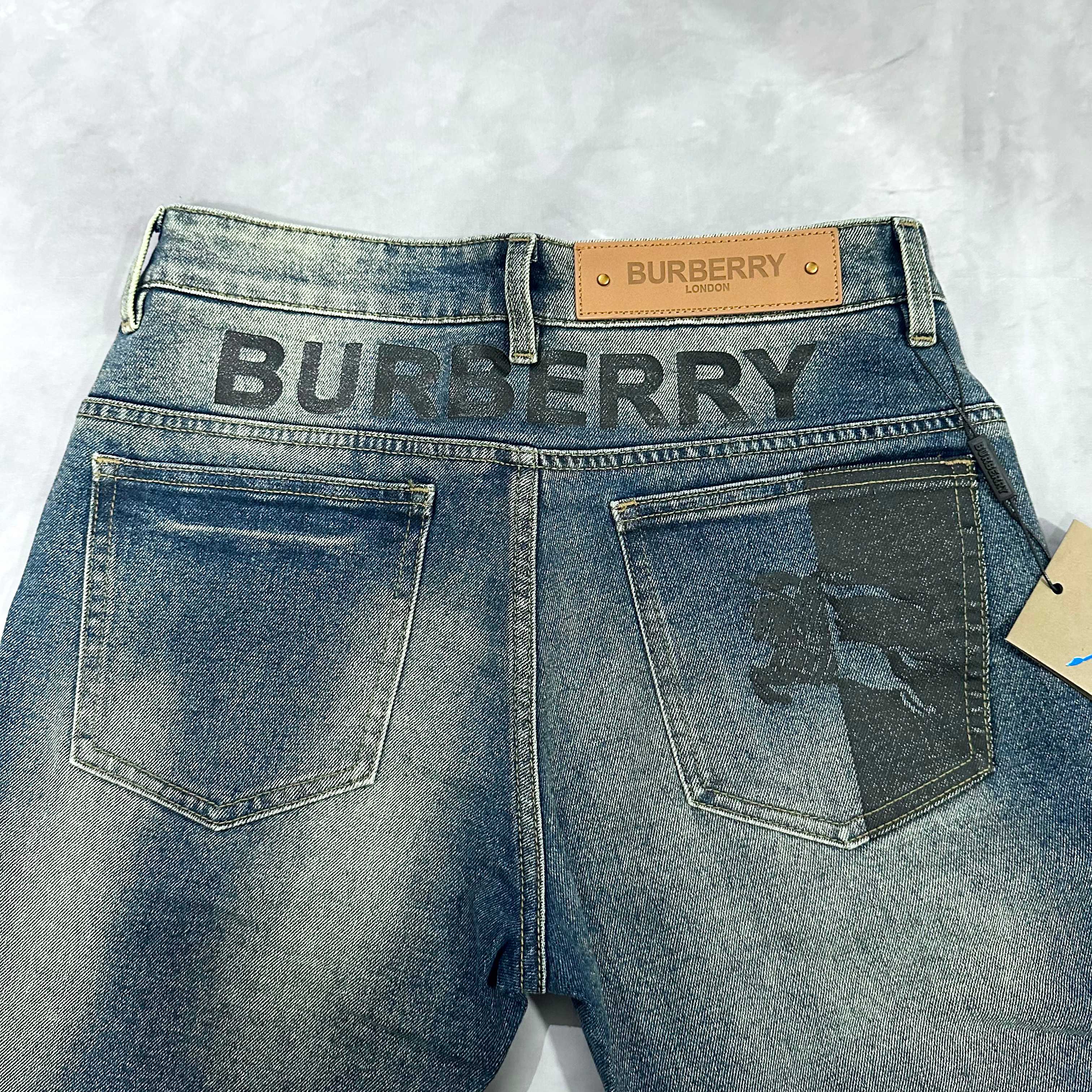 Burberry blue denim jeans front with large patch pockets and logo waistband