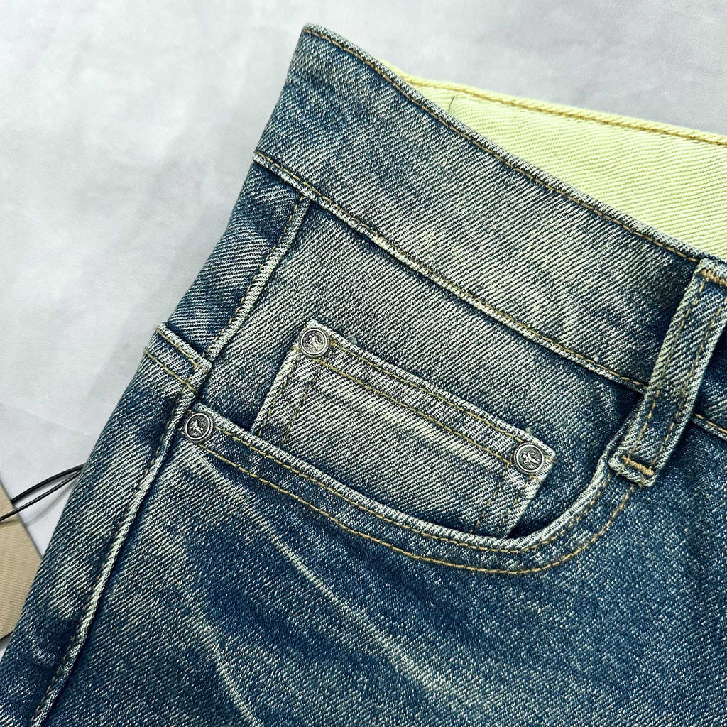 Burberry blue denim jeans close-up of waistband, button, and coin pocket