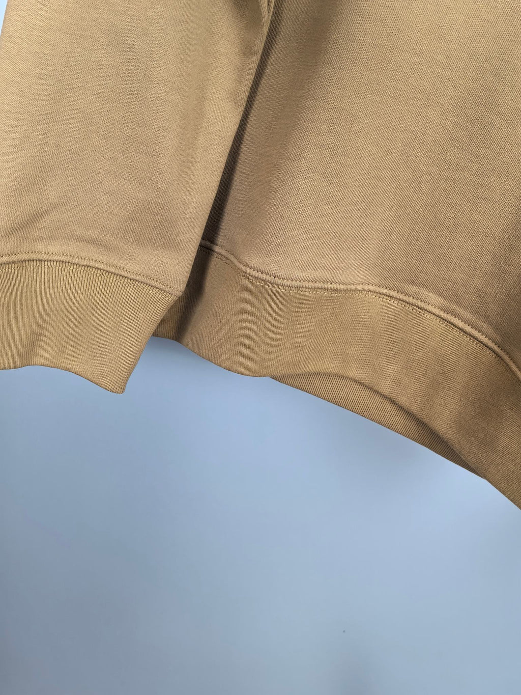 Tan hoodie lower sleeve and curved side seam with rib knit trim