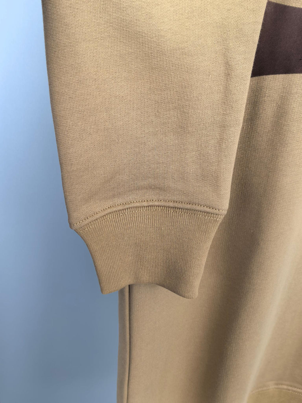 Tan hoodie sleeve cuff and ribbed hem, fabric texture detail