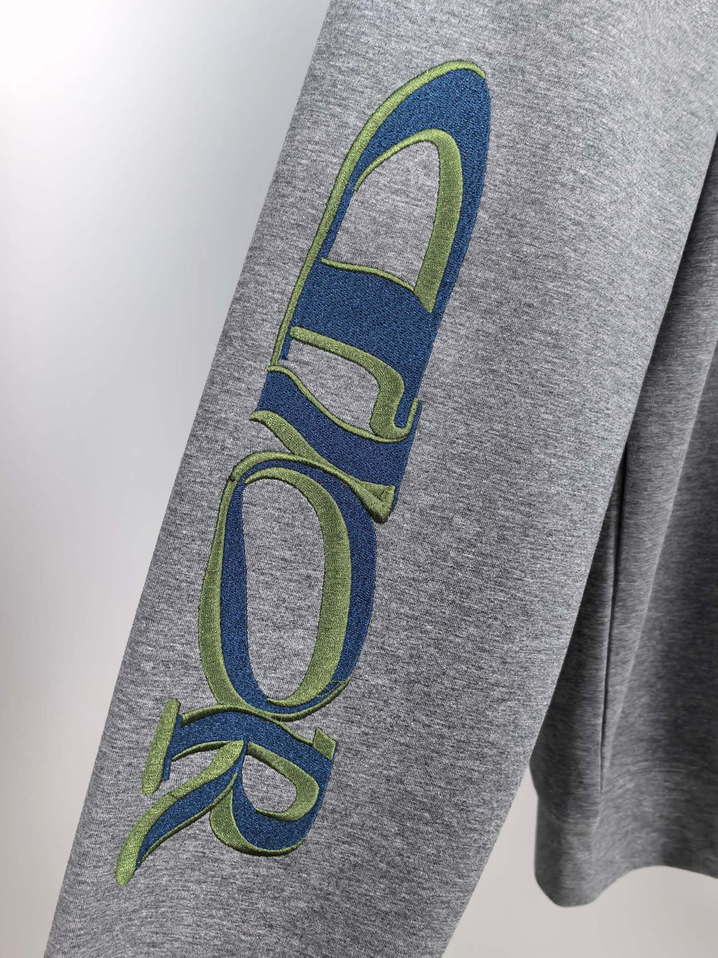 Dior long-sleeve sweatshirt heather gray with large blue-green “Dior” sleeve print