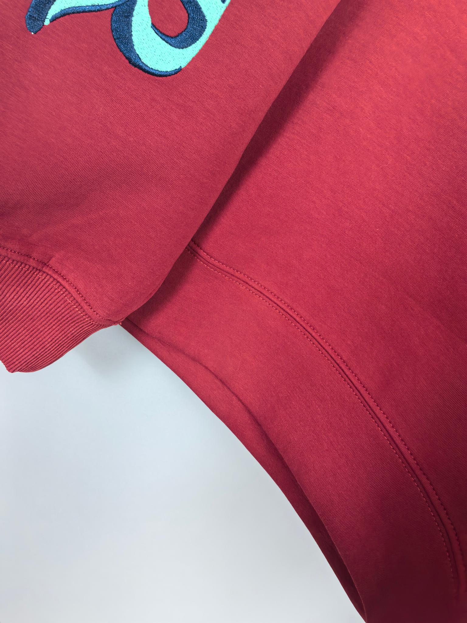 Red sweatshirt with ribbed cuffs and visible side seam detail