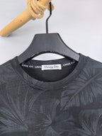 Long-sleeve sweatshirt neckline with inner brand tag, dark gray leaf print.