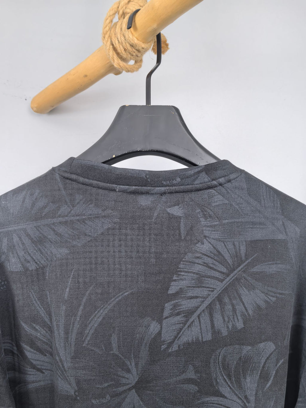 Long-sleeve sweatshirt with dark gray leaf print, crew neckline shown.