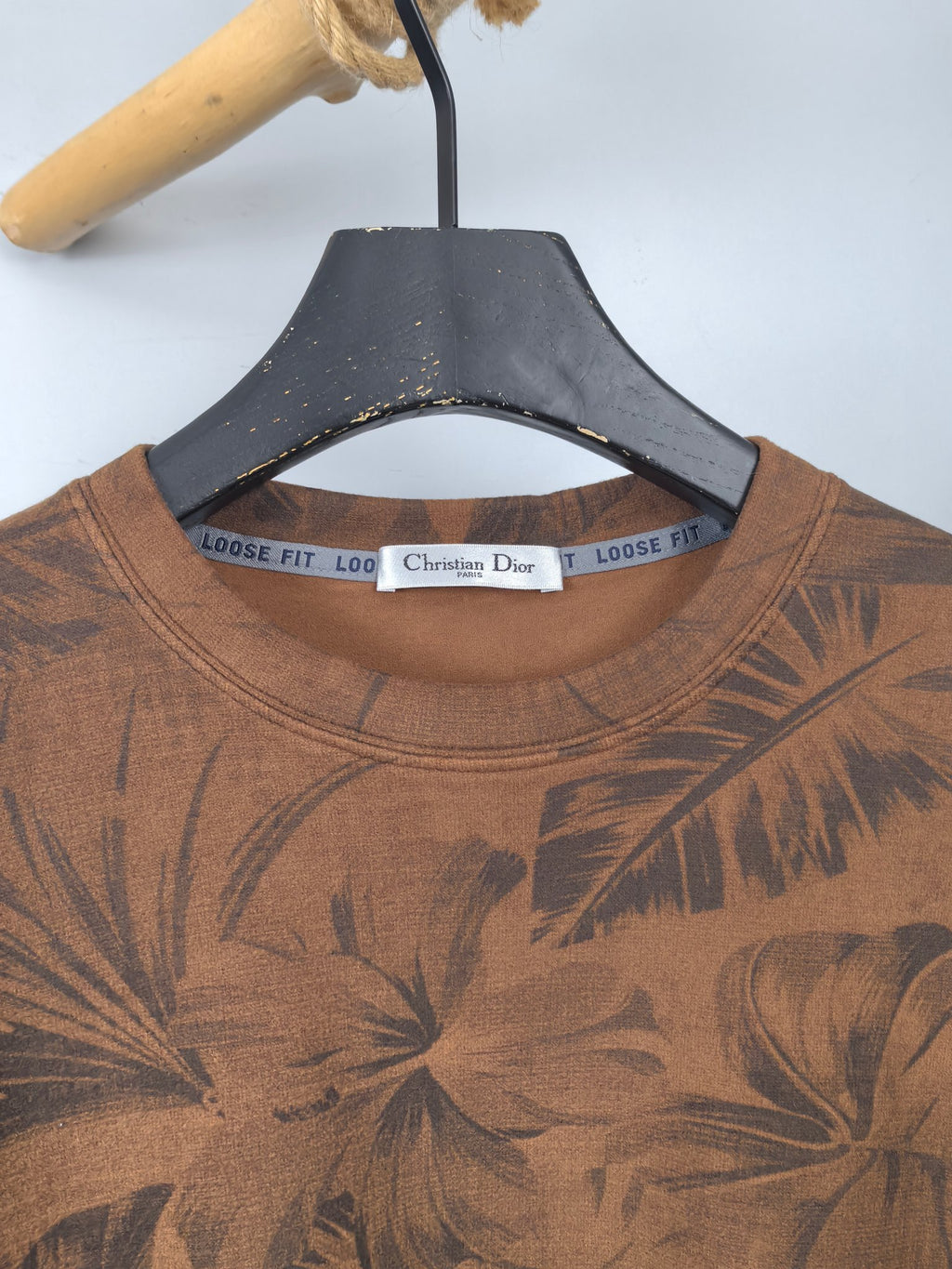 Brown crew-neck long-sleeve top with dark tropical leaf print and Dior neck label
