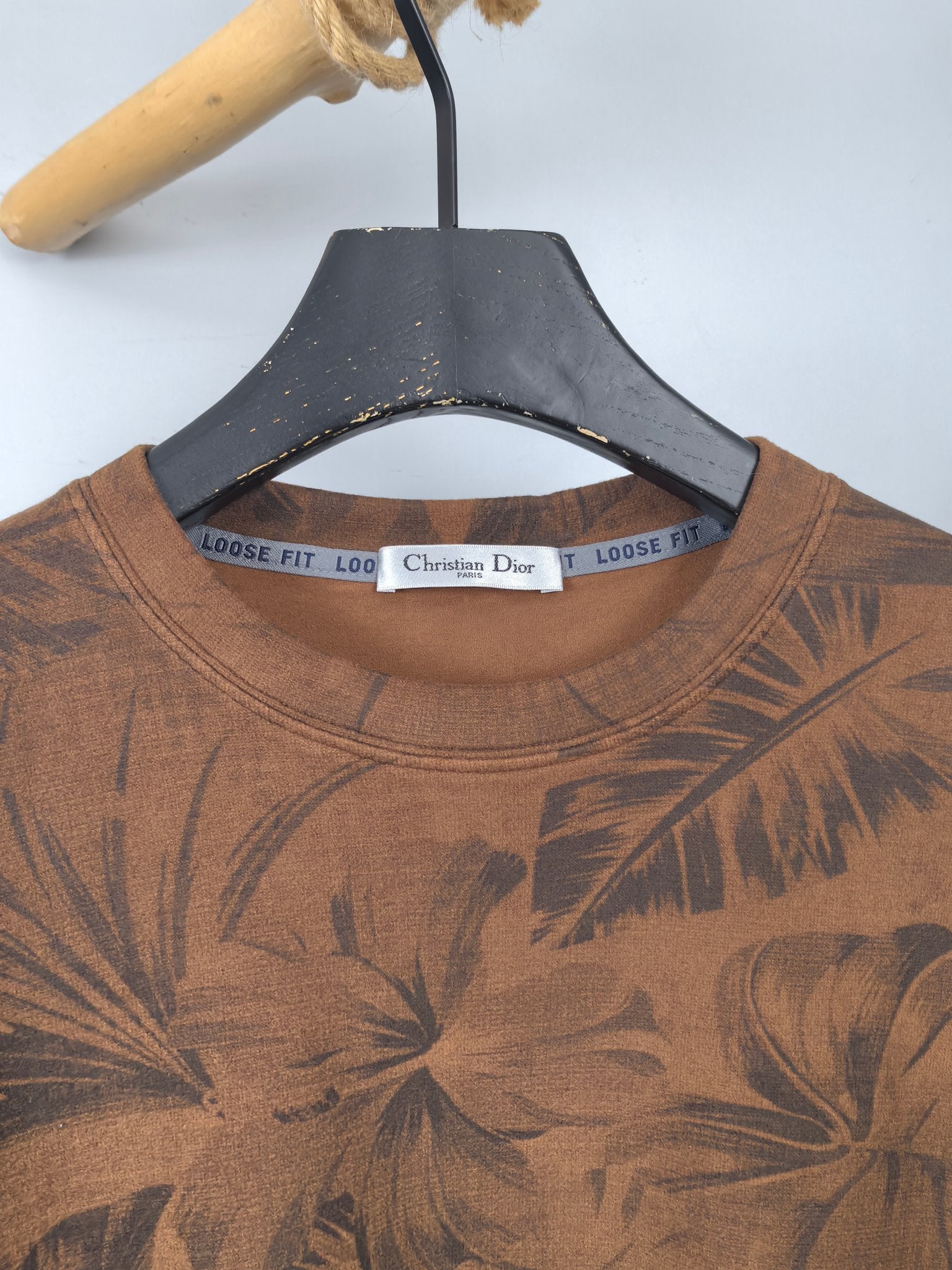 Brown crew-neck long-sleeve top with dark tropical leaf print and Dior neck label