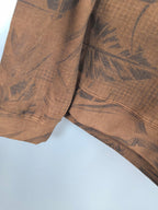 Brown long-sleeve top with dark tropical leaf pattern and ribbed hem