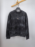 Dark gray crewneck sweatshirt with large camo-style text graphic on the front