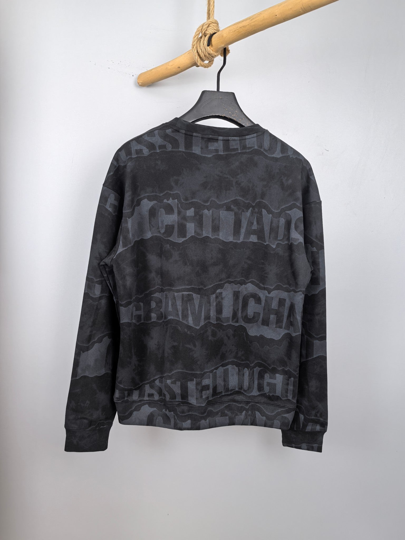 Dark gray crewneck sweatshirt with camo-style text graphic on the back