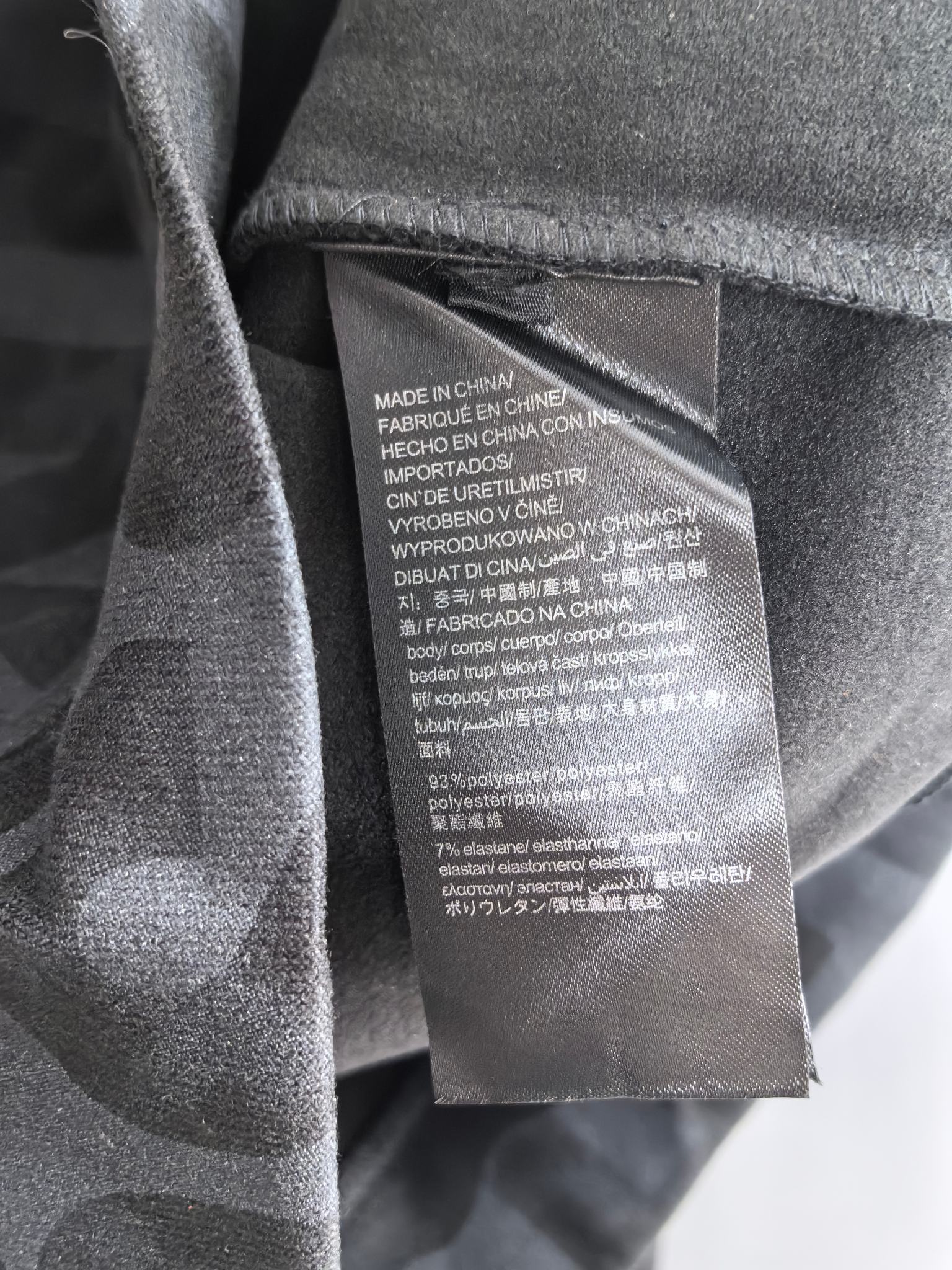 Interior care label on dark gray sweatshirt, showing “Made in China” text