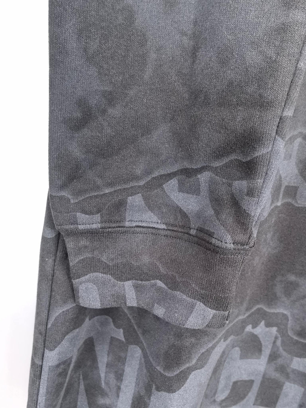 Dark gray crewneck sweatshirt side with graphic pattern and stitched seam
