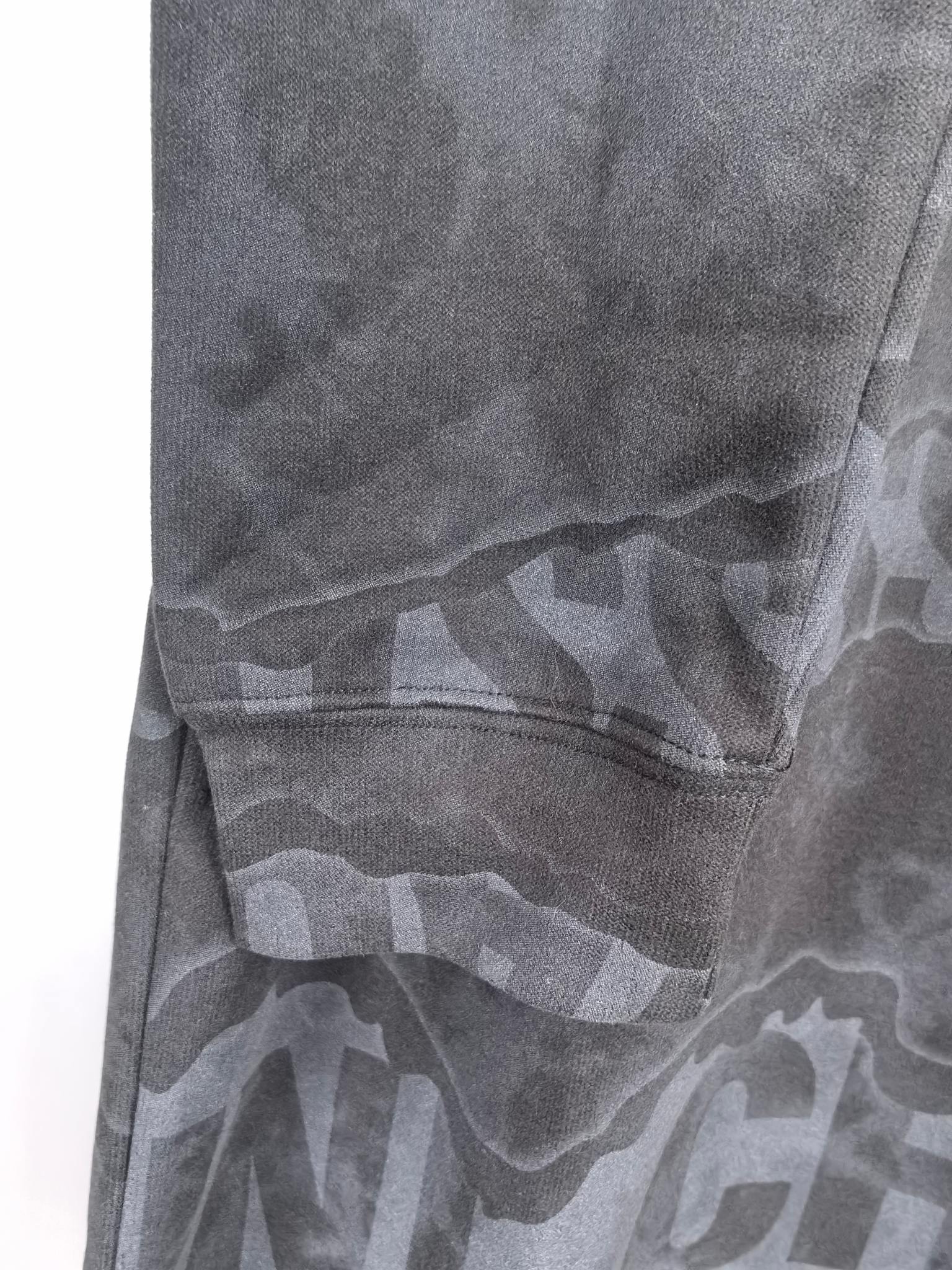Dark gray crewneck sweatshirt side with graphic pattern and stitched seam