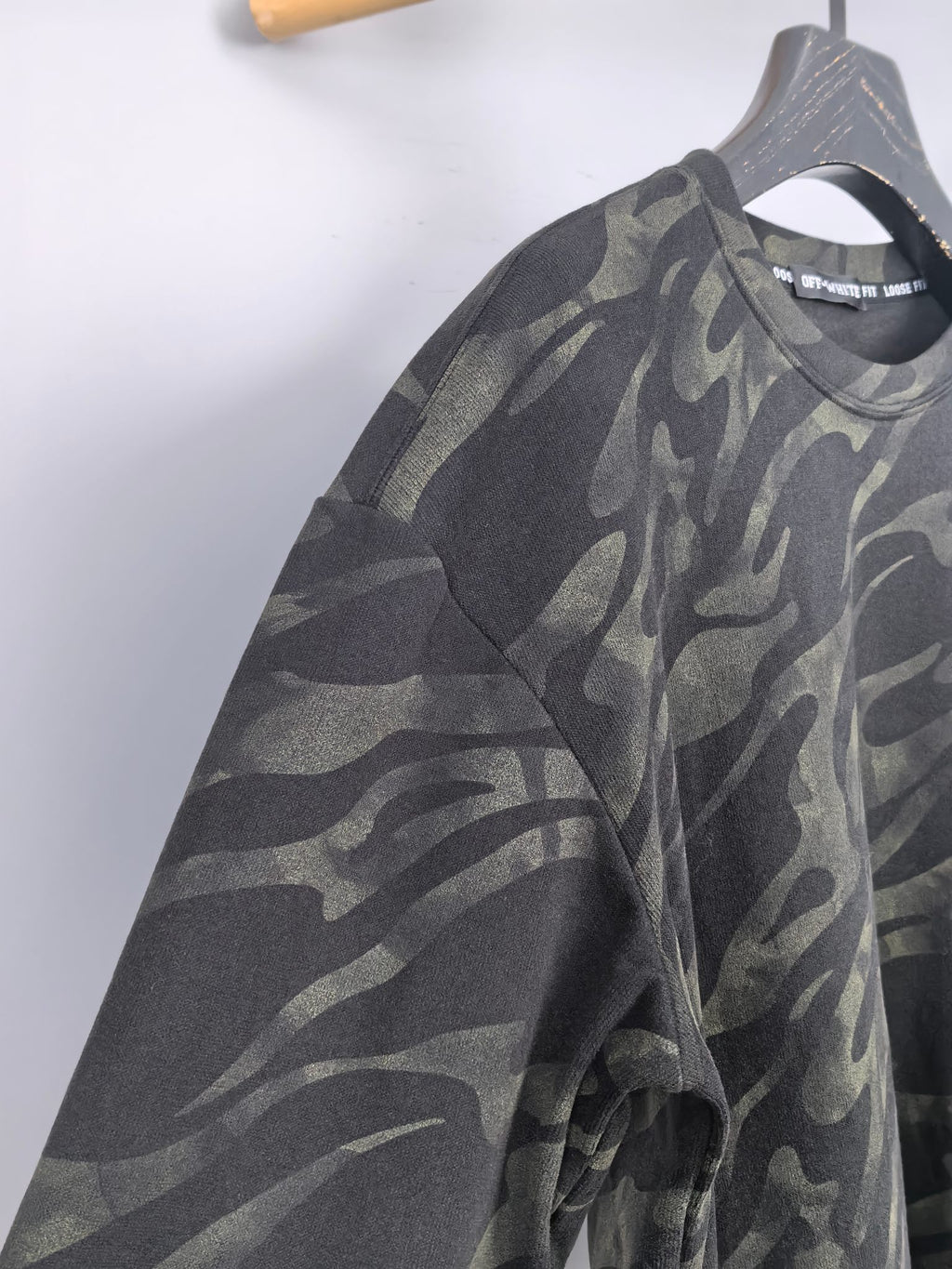 Camo crewneck sweatshirt on hanger, side view, dark gray and olive pattern