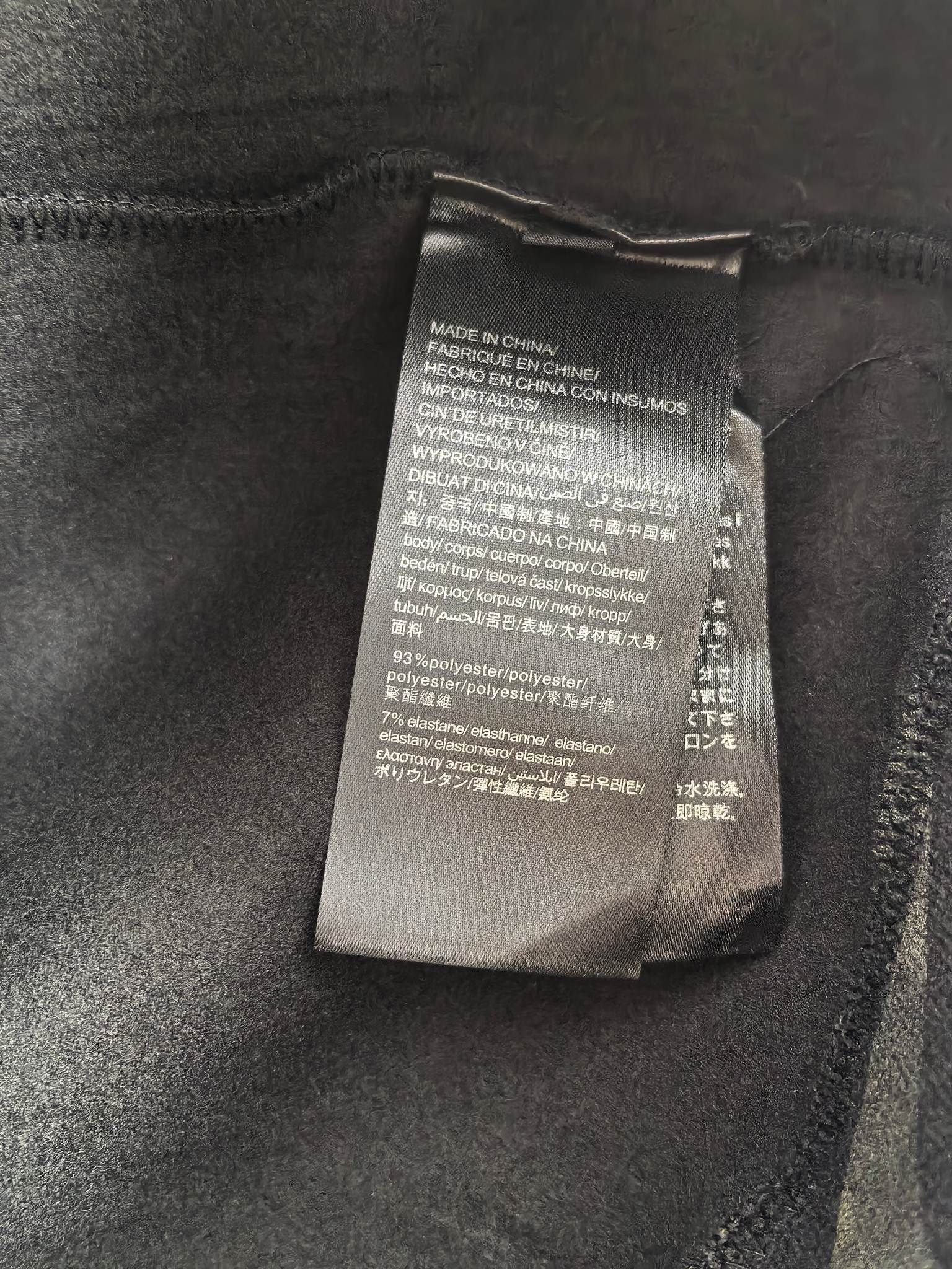 Interior care label on dark camo crewneck sweatshirt, fabric tag detail