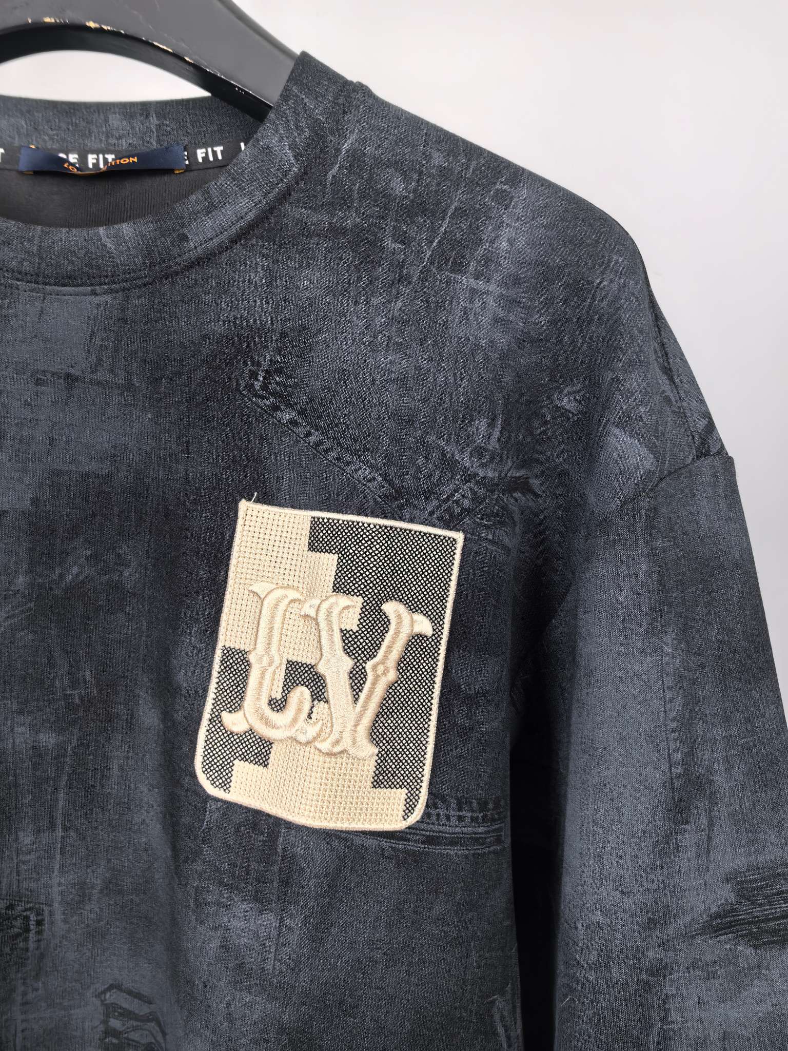 Dark navy sweatshirt with square Louis Vuitton logo patch on chest