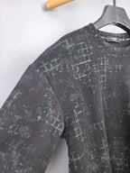 Black long-sleeve sweatshirt with green grid pattern, angled side view