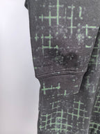 Black sweatshirt sleeve cuff with green grid pattern and ribbed cuff detail