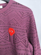 Maroon knit sweater front detail with red pixel heart motif and geometric pattern