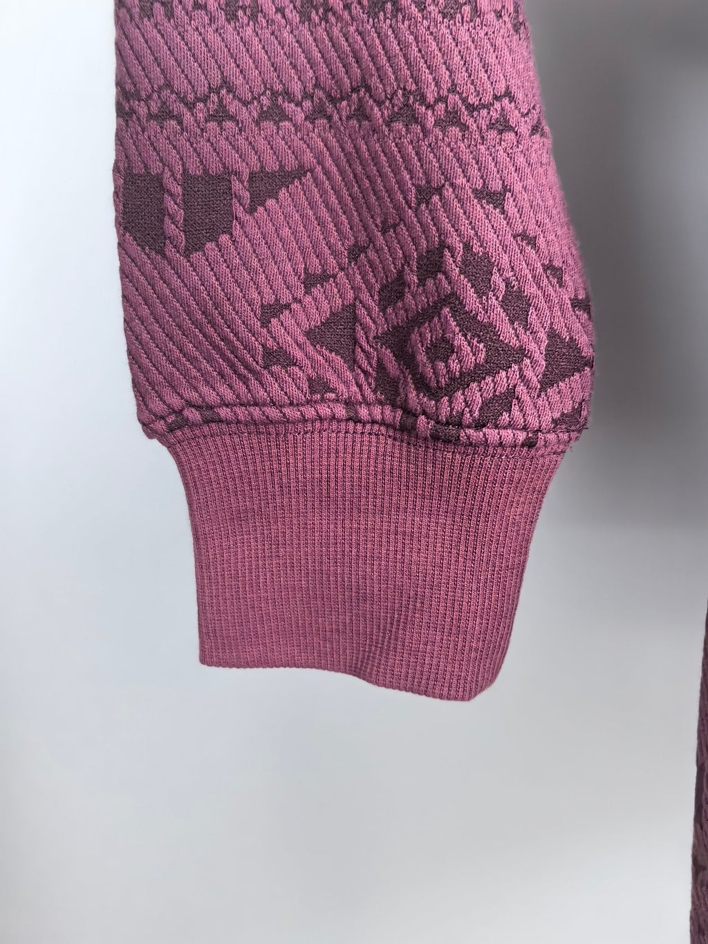 Maroon knit sweater hem and cuff with geometric texture pattern