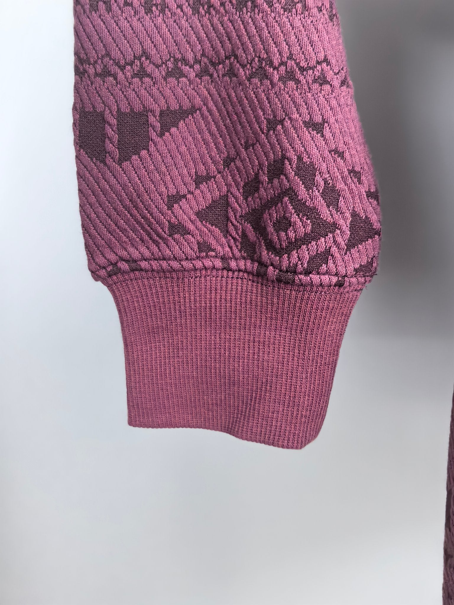 Maroon knit sweater hem and cuff with geometric texture pattern