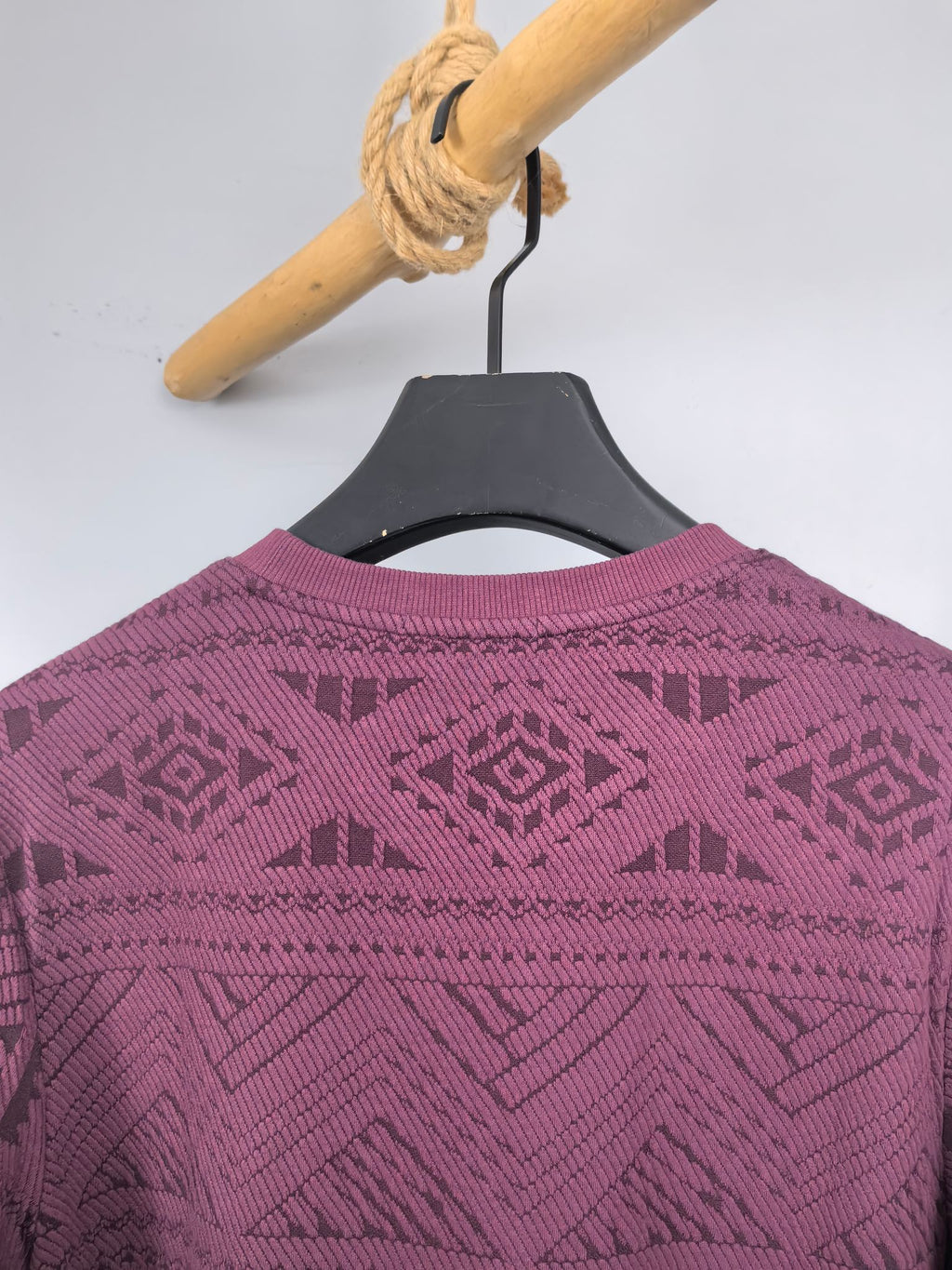 Maroon knit sweater back view with geometric pattern across shoulders and back