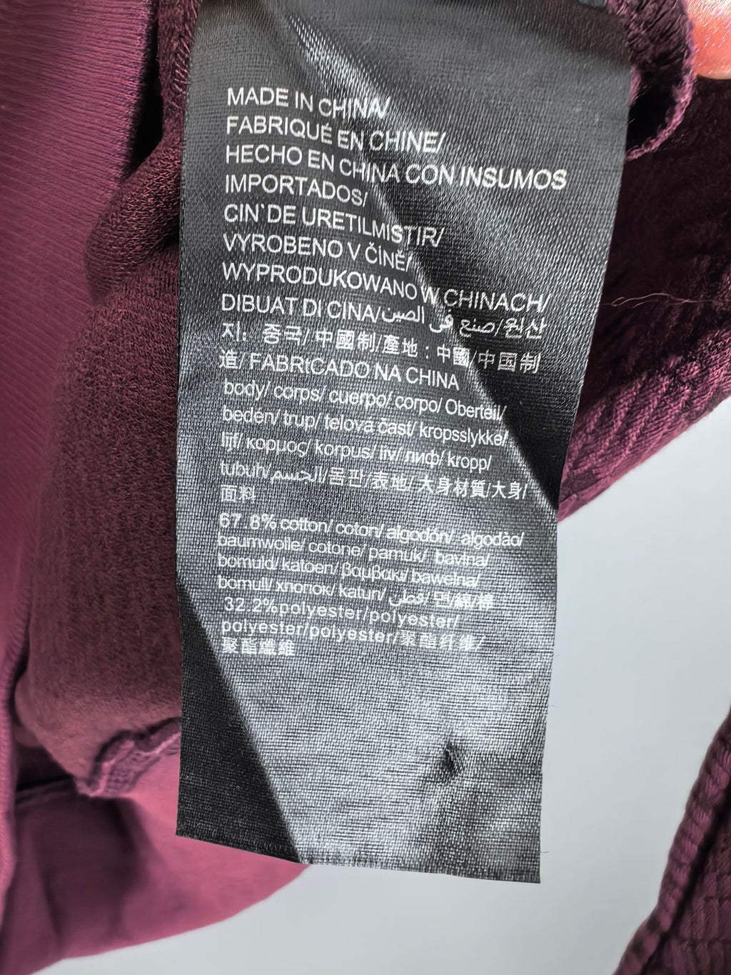 Maroon knit sweater care label tag on interior side