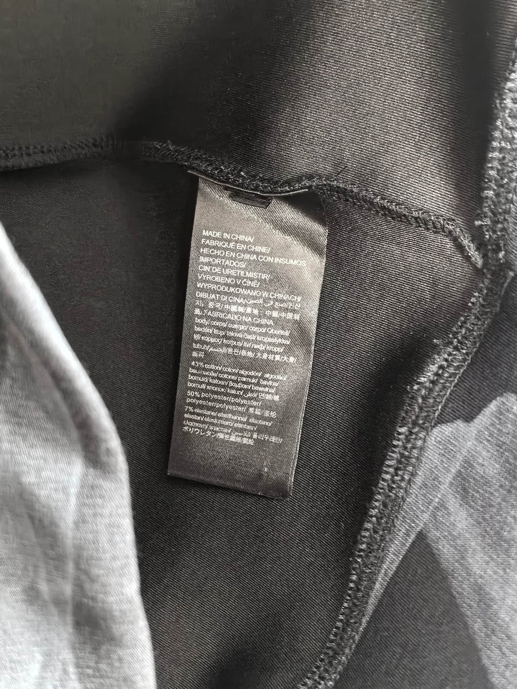 Long-sleeve top interior care label on dark fabric