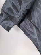 Long-sleeve top sleeve detail with layered abstract print and textured knit