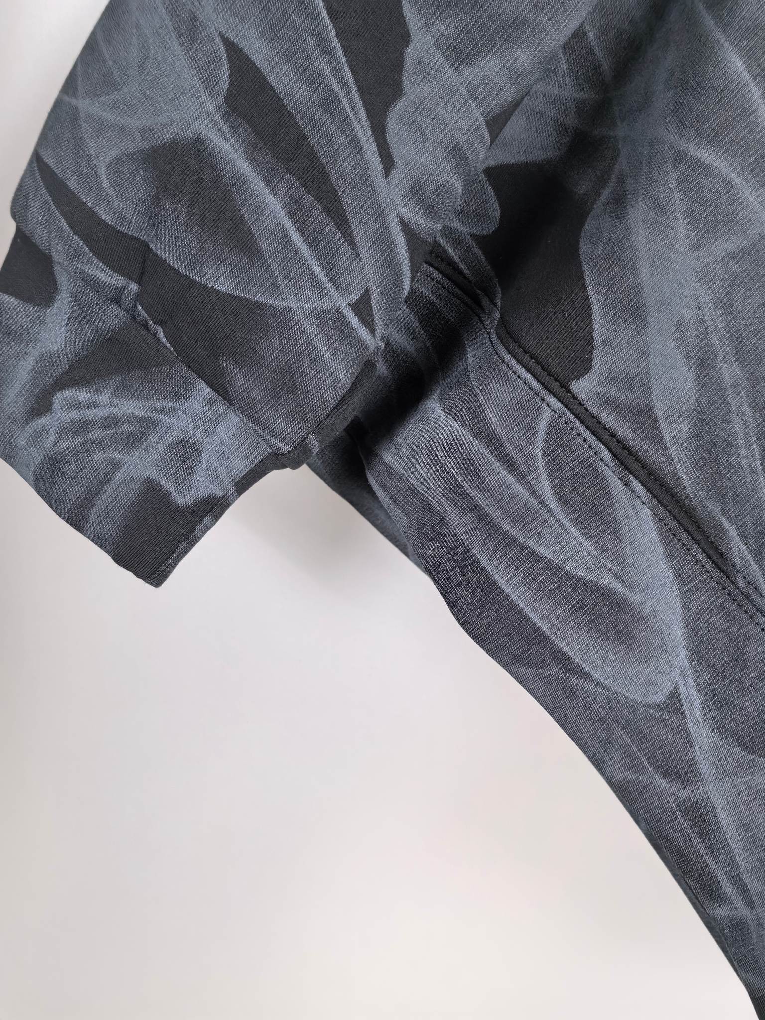 Long-sleeve top sleeve detail with layered abstract print and textured knit