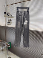 Gray denim pants with elastic waistband, white drawstring, graphic logo patch