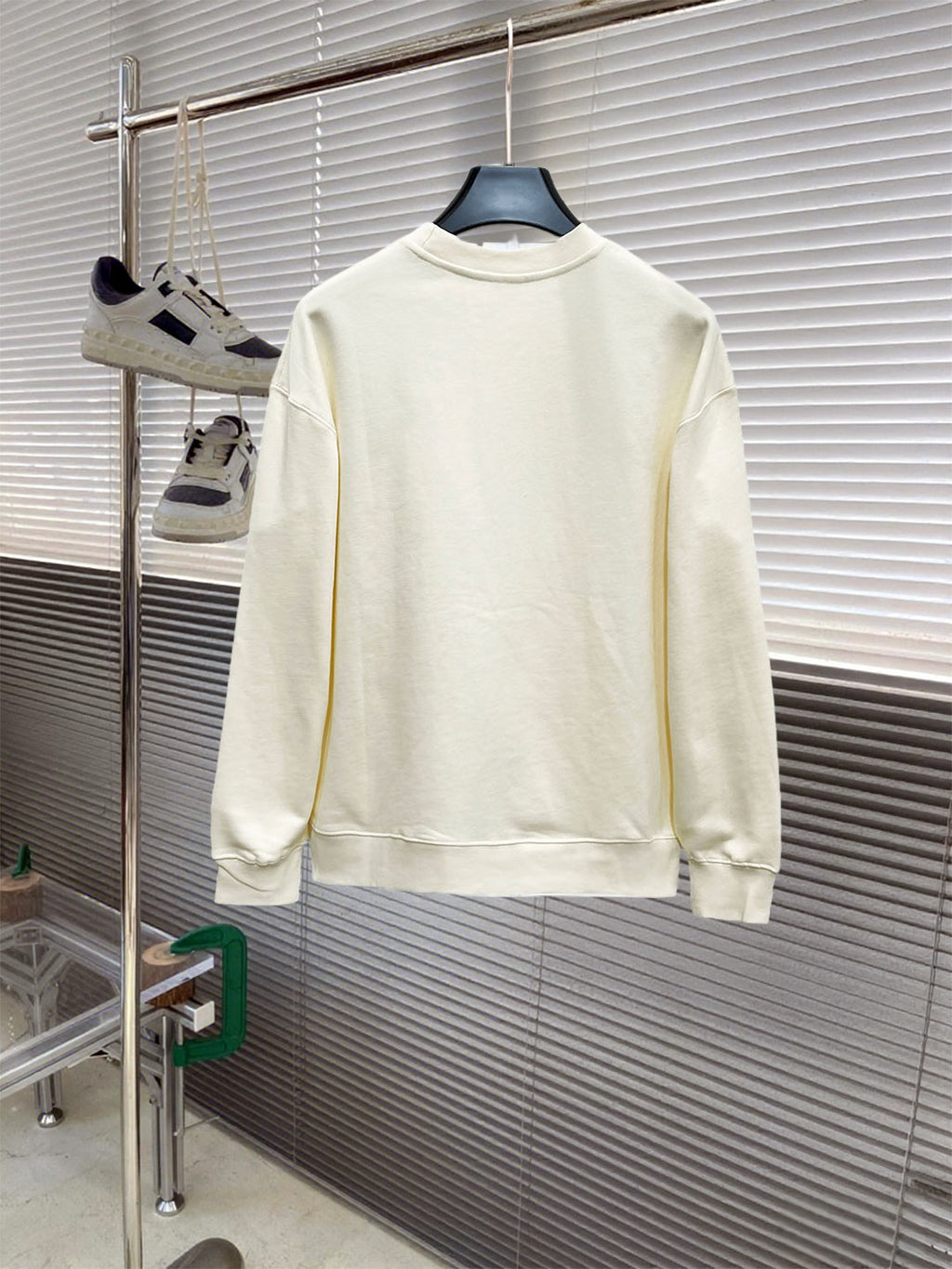 Cream long-sleeve crewneck sweatshirt, back view on hanger; graphic not visible.