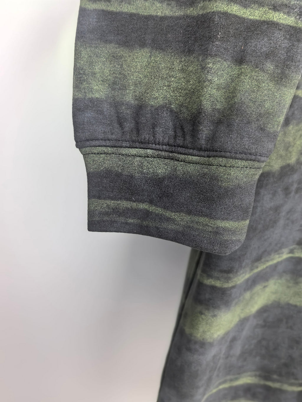 Prada sweatshirt sleeve cuff, dark gray with green horizontal stripes.