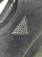 Prada sweatshirt chest detail with studded triangle patch, dark gray and green stripes.