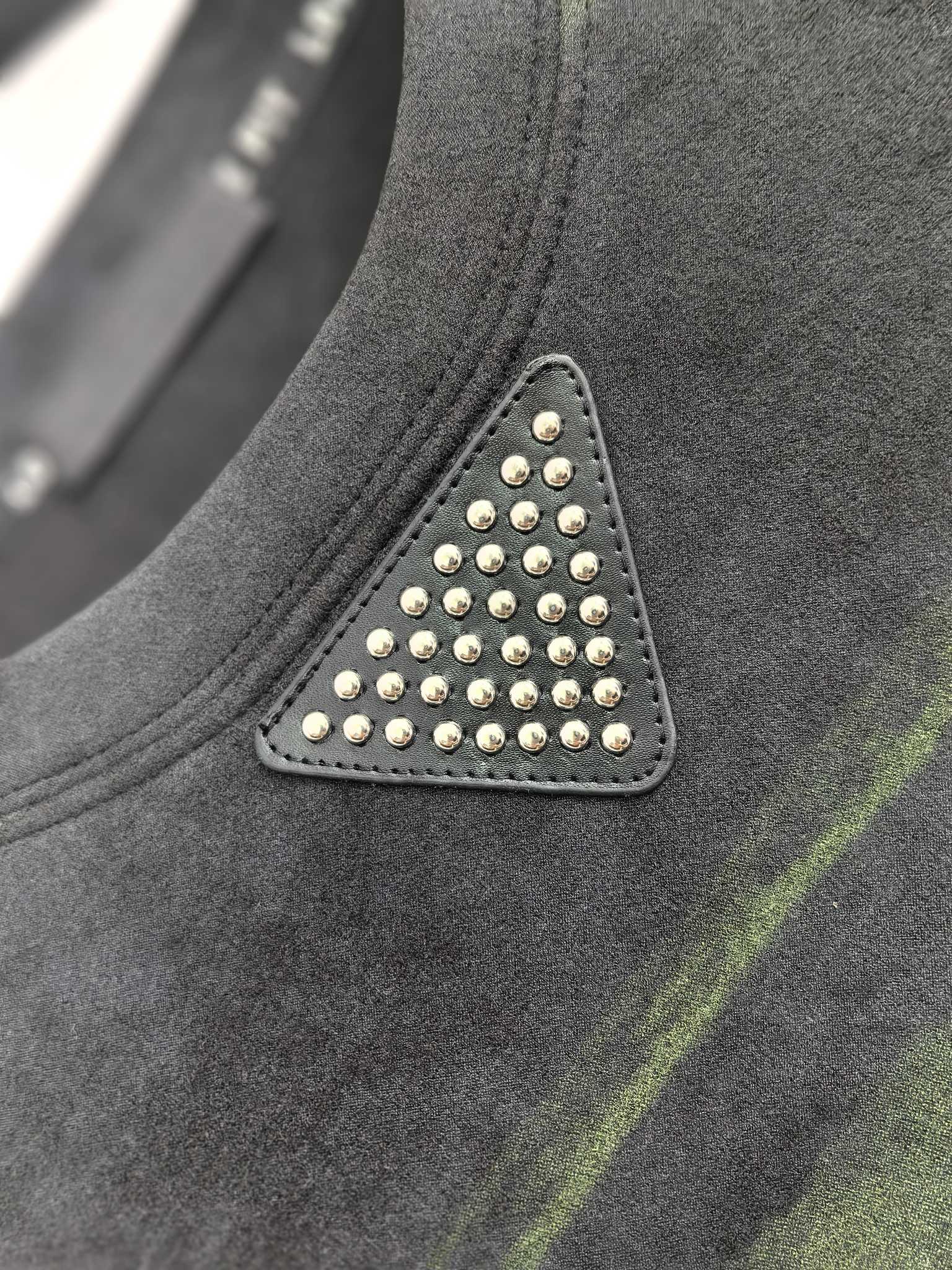 Prada sweatshirt chest detail with studded triangle patch, dark gray and green stripes.