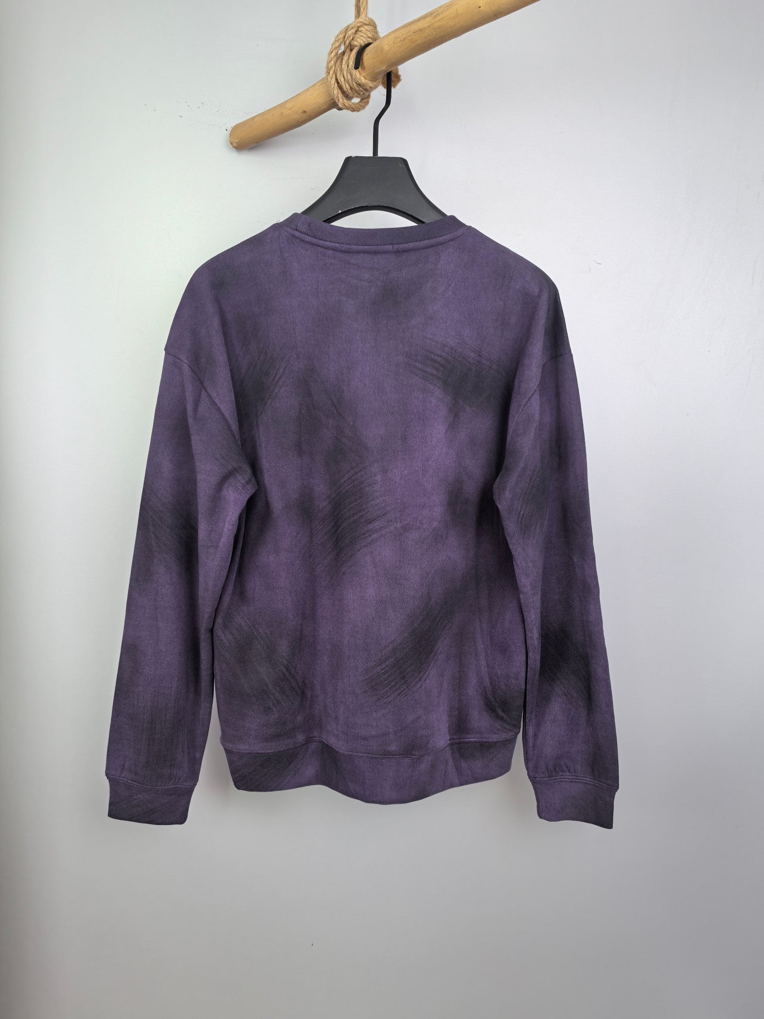 Purple long-sleeve sweatshirt on hanger, back view with crew neckline.