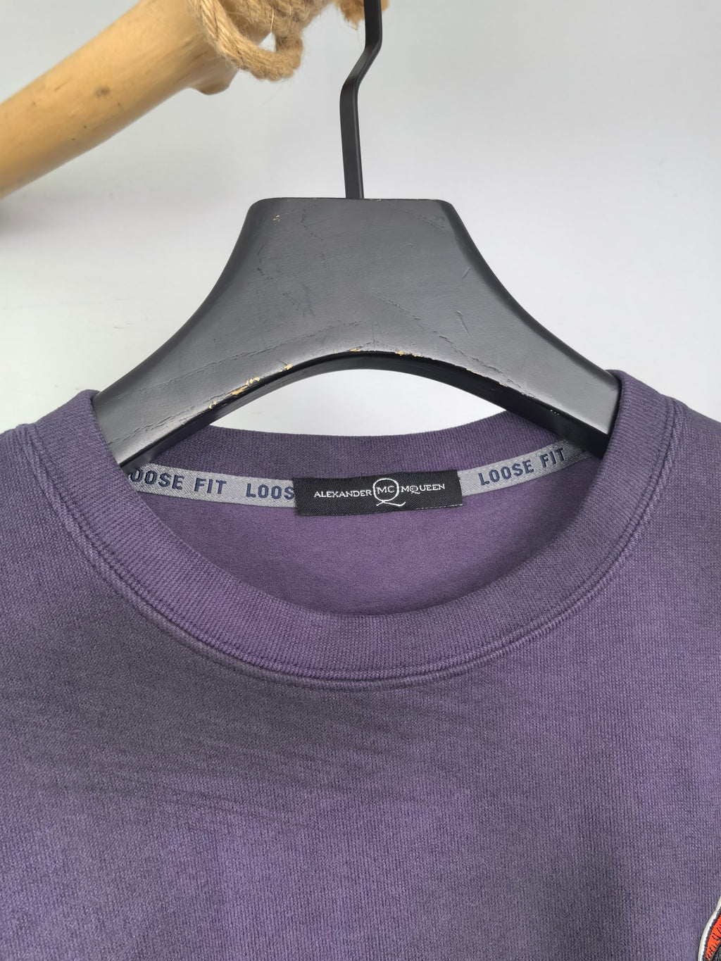 Purple sweatshirt crew neck with size label tape inside collar.