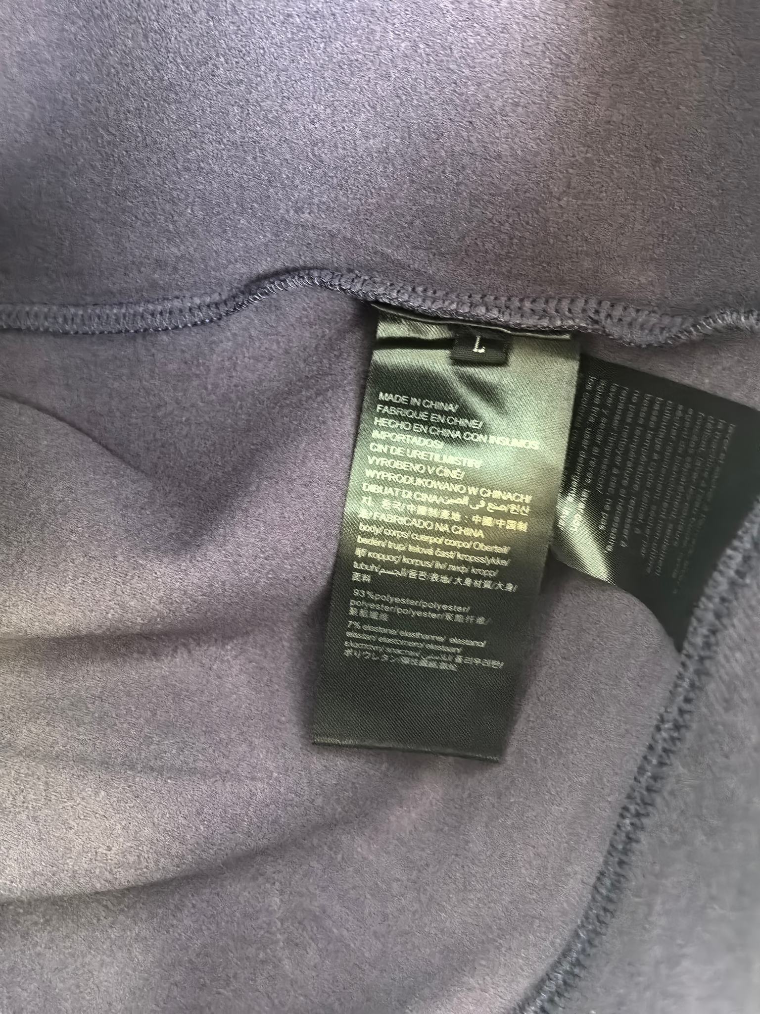 Purple sweatshirt inside neck label tag sewn to inner seam.