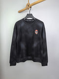 Long-sleeve crewneck shirt, dark charcoal, small chest patch graphic on left side