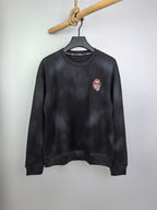 Long-sleeve crewneck shirt, dark charcoal, small chest patch graphic on left side