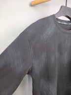 Long-sleeve crewneck shirt with textured dark charcoal knit, side shoulder seam close-up