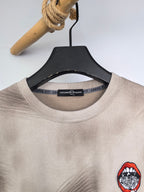 Light beige crewneck sweatshirt collar with interior label and red chest graphic.