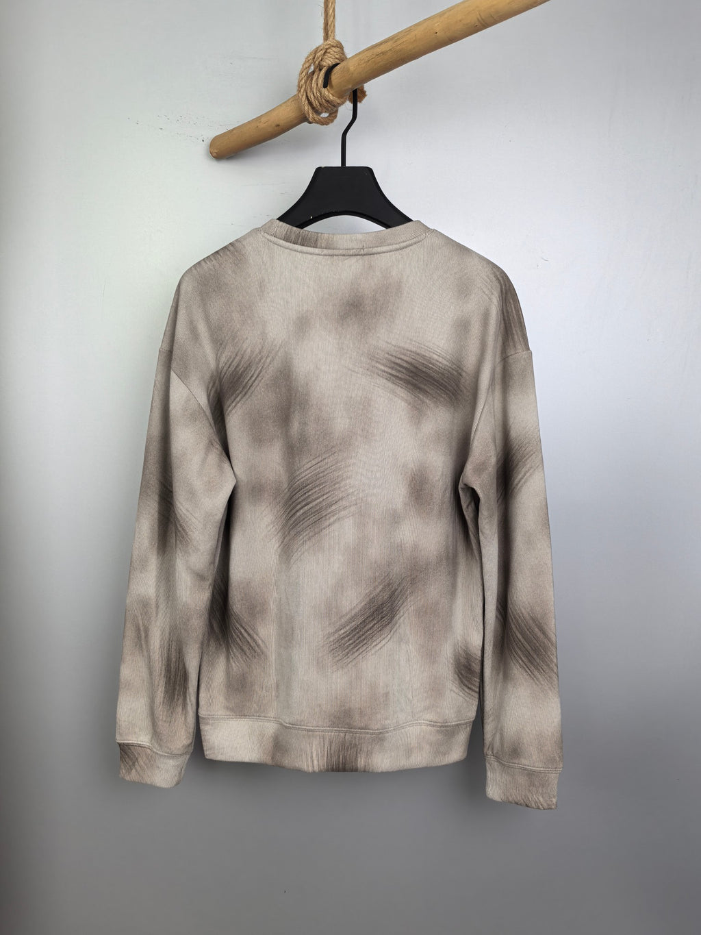 Light beige long-sleeve crewneck sweatshirt, back view on hanger.