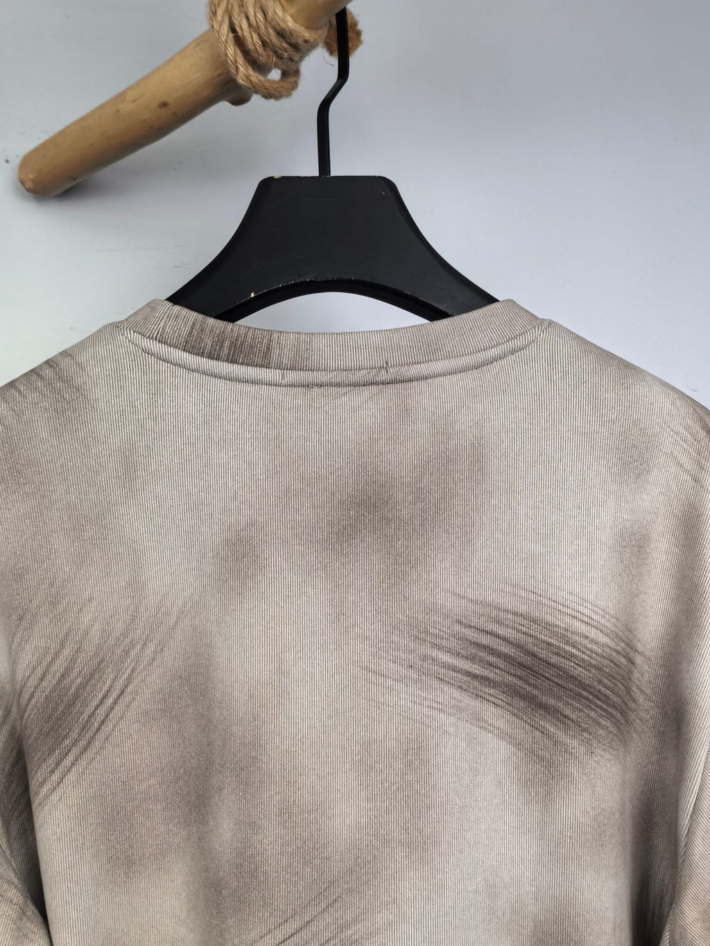 Light beige sweatshirt back view with crew neckline on hanger.