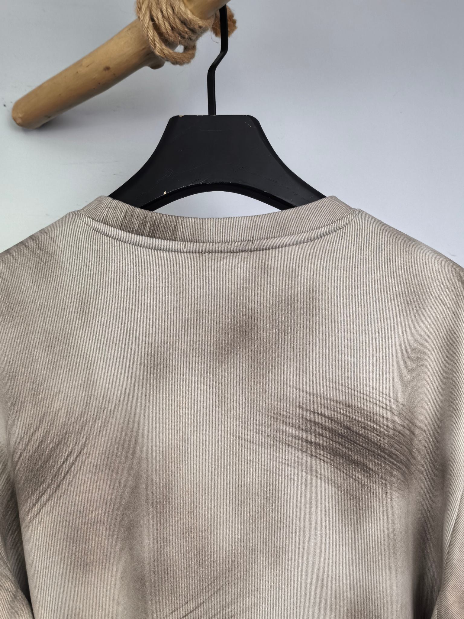 Light beige sweatshirt back view with crew neckline on hanger.
