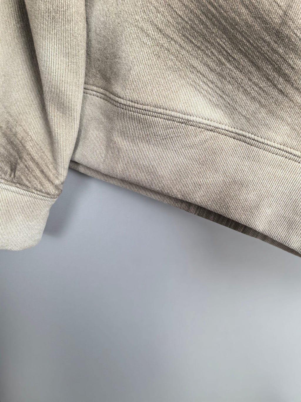 Light beige sweatshirt hem and ribbed band at waist seam.