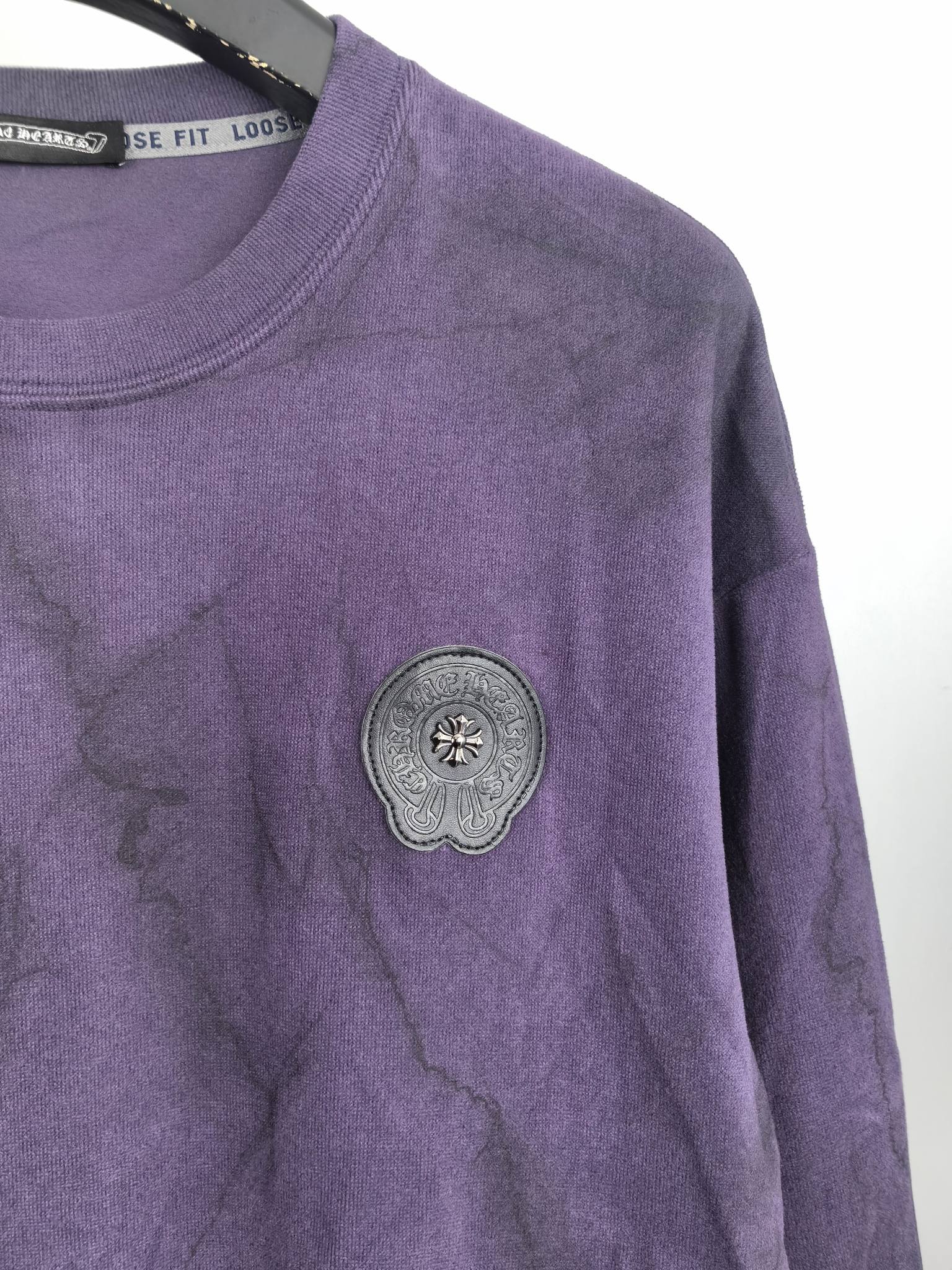 Purple crewneck sweatshirt with round decorative patch on the chest