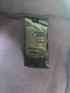 Inside neck label on purple sweatshirt with care and origin text