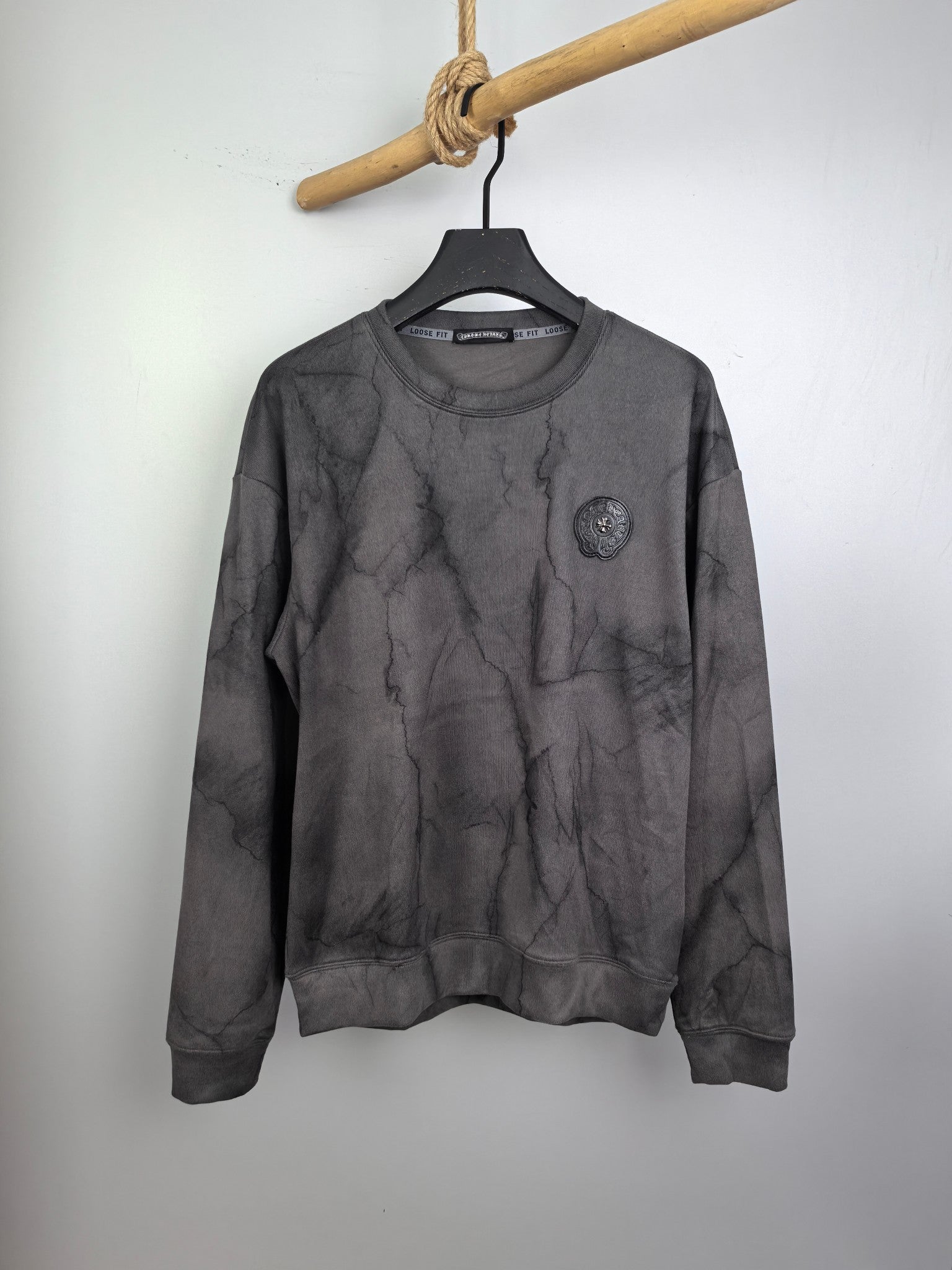 Dark gray marble print crewneck long-sleeve sweatshirt with small chest badge